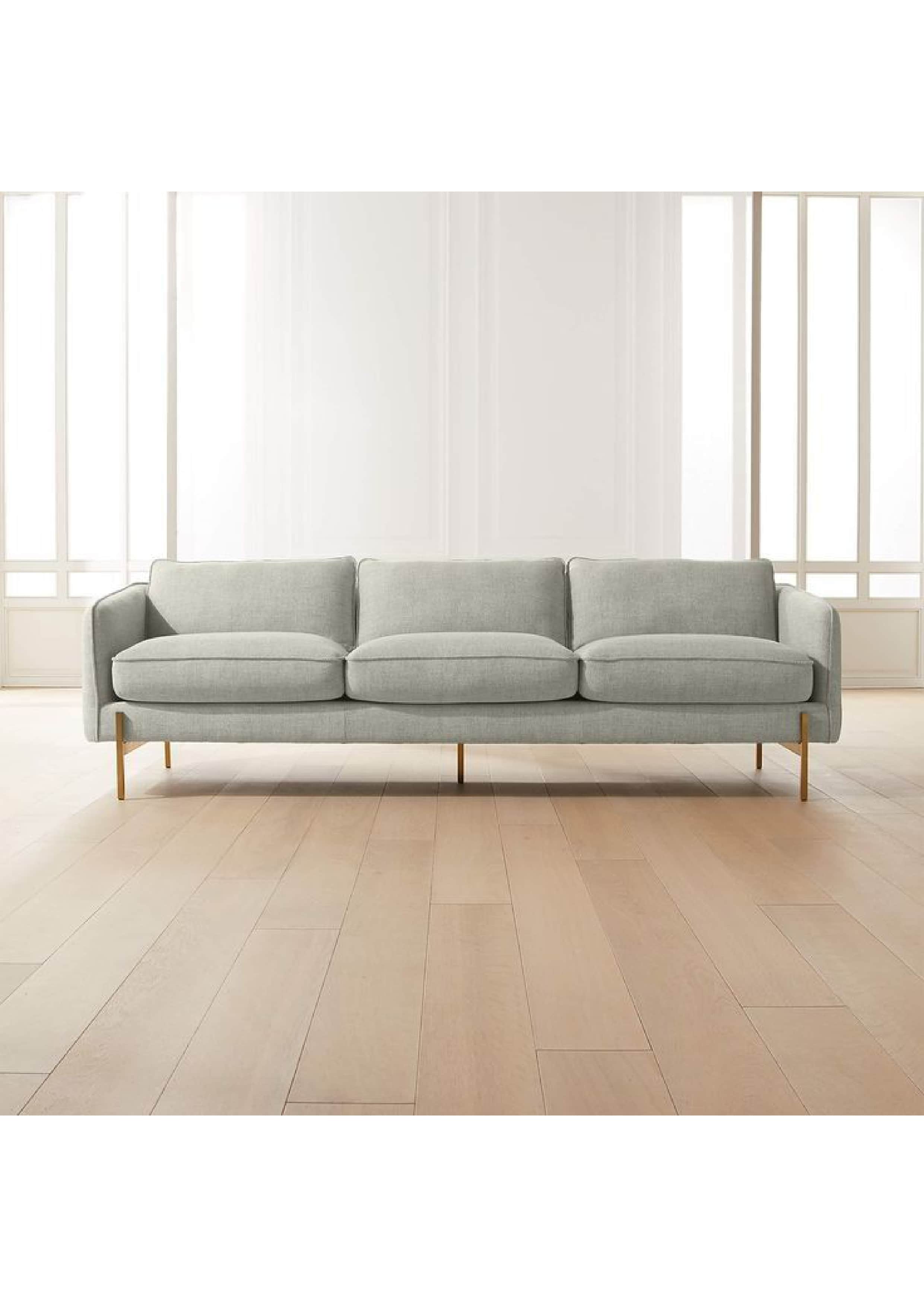 A modern three-seater sofa upholstered in a light grey fabric, featuring three distinct back cushion… — 3D model