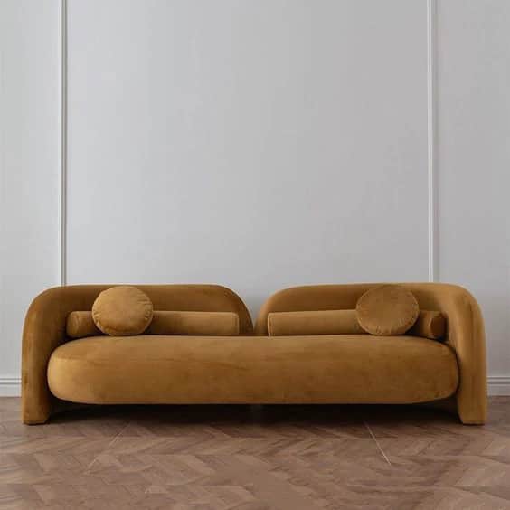 An asymmetrical daybed upholstered in mustard yellow velvet, featuring a distinct rounded, continuou… — 3D model