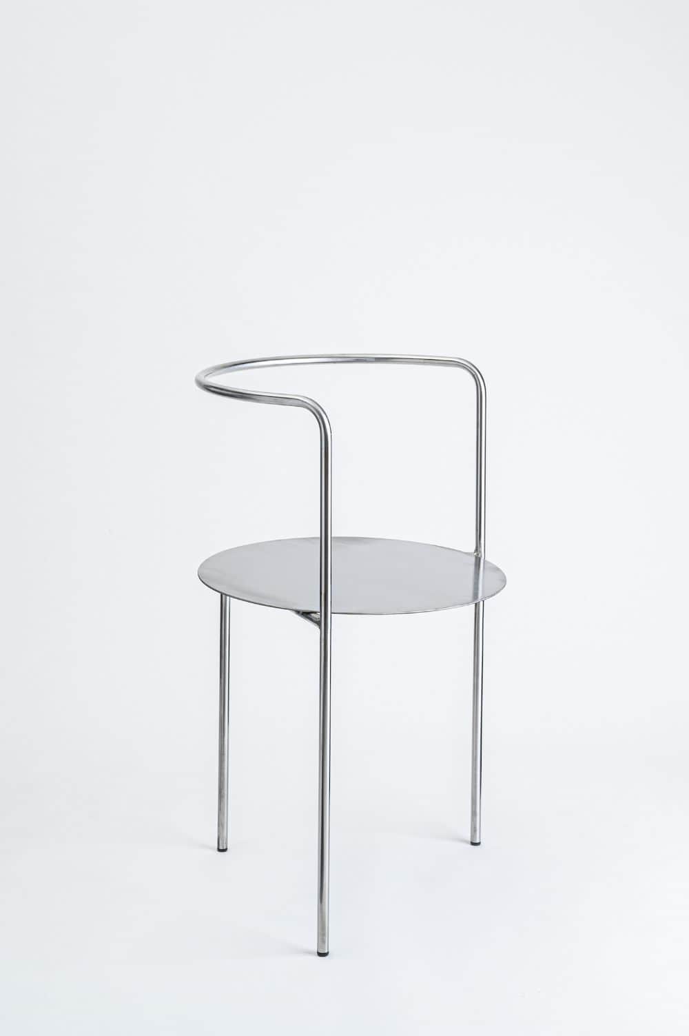 A minimalist chair constructed from bent metal tubing for the frame and legs, supporting a circular… — free FBX 3D model