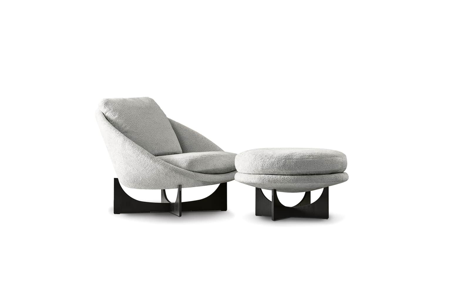 A modern armchair with a matching ottoman, both featuring a rounded, organic silhouette upholstered… — 3D model