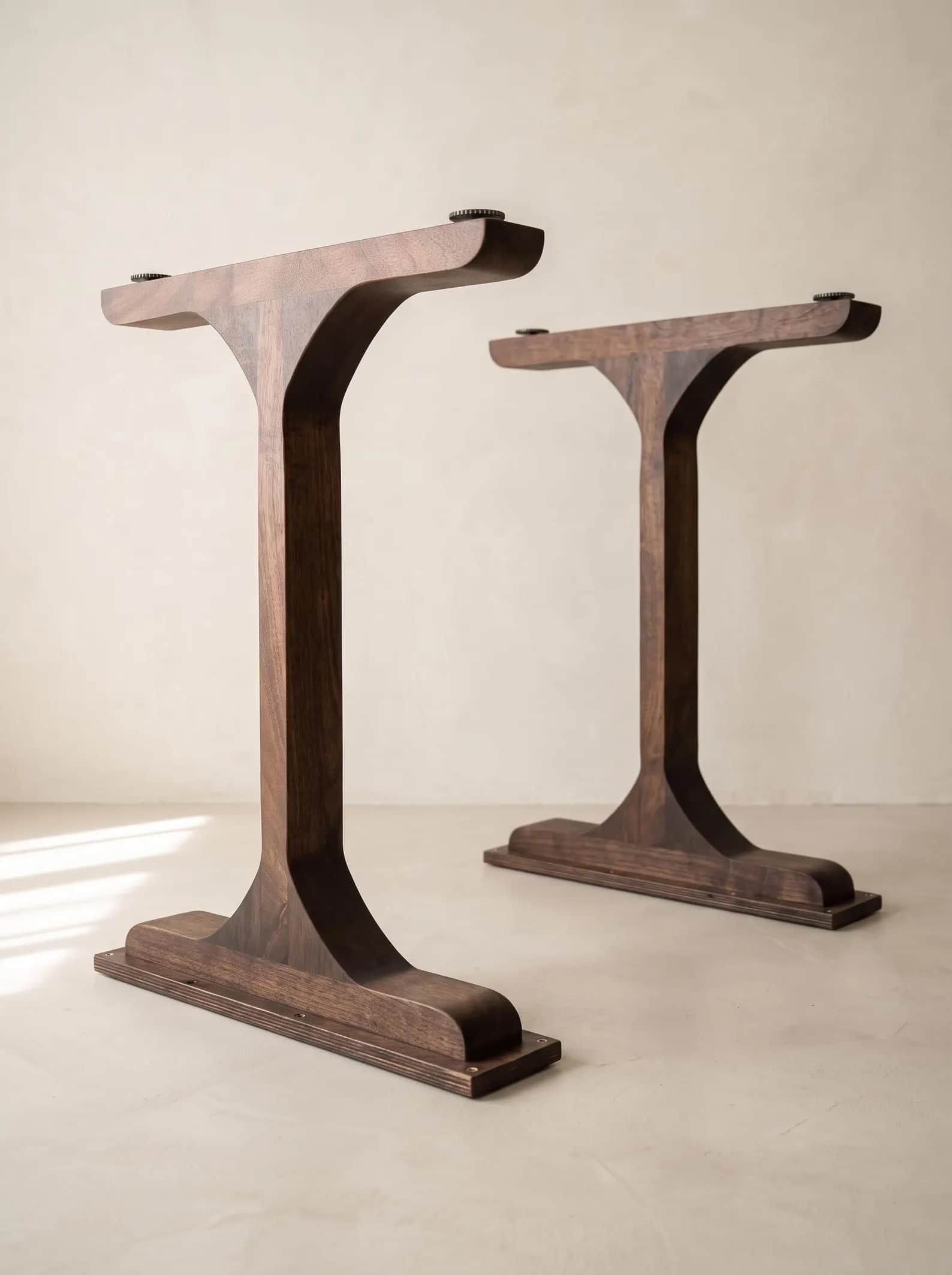 A modern T-shaped table base crafted from dark-stained wood, featuring a central column flaring into… — 3D model