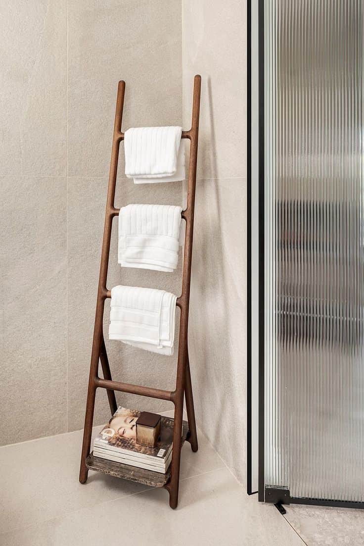 A dark brown wooden leaning ladder-style towel rack featuring three rounded rungs for hanging textil… — 3D model