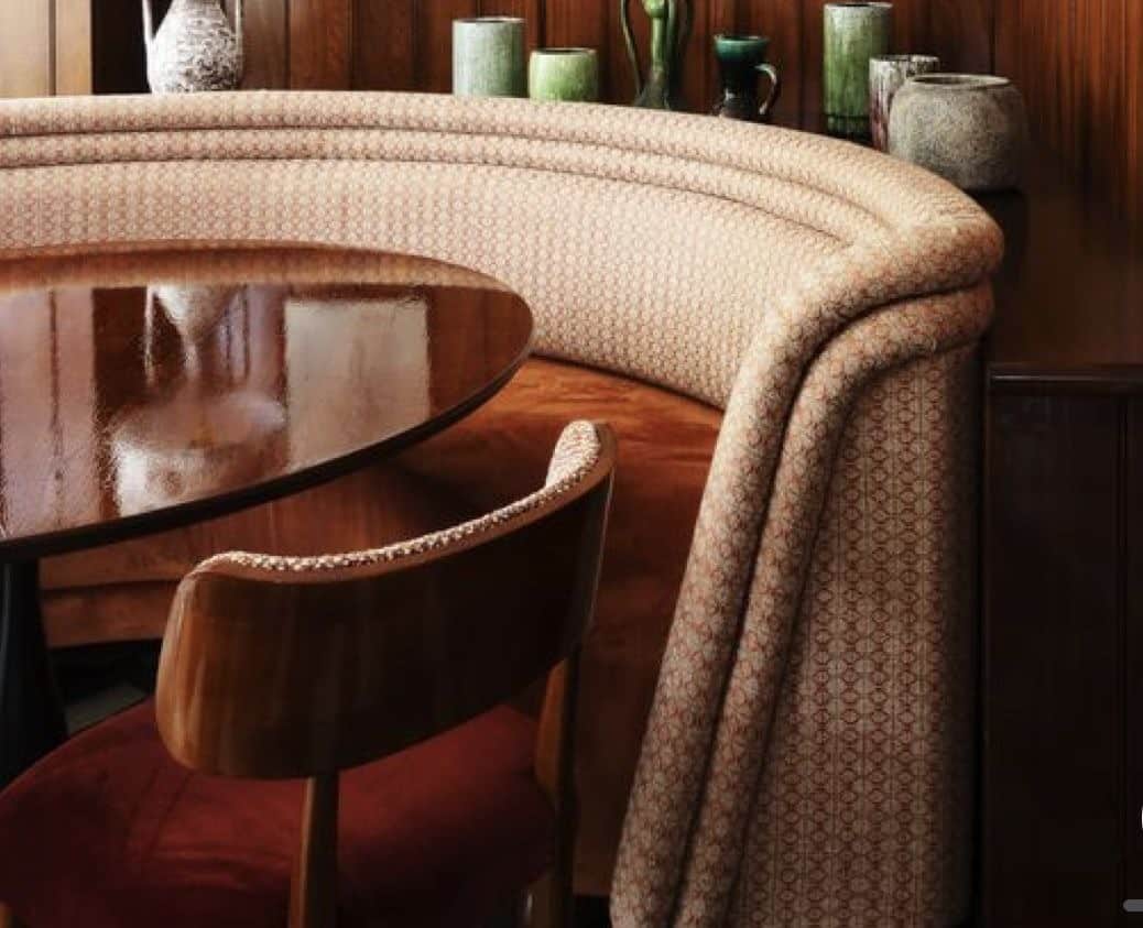A semi-circular, multi-person booth seating unit featuring a high, slatted wood backrest and a two-t… — 3D model