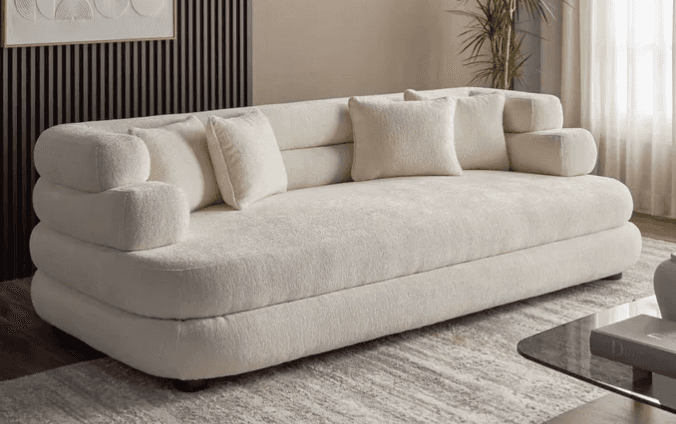 A modern sofa upholstered in a light cream bouclé fabric, featuring a distinctive low-profile design… — free GLTF 3D model