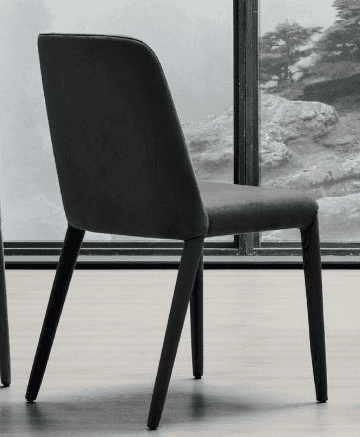 A modern upholstered chair with a curved backrest and four tapered legs. The chair has a minimalist… — 3D model