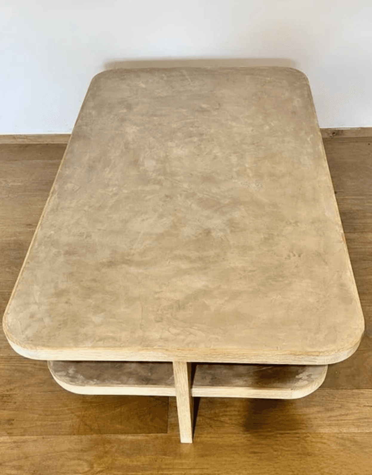 A rectangular coffee table featuring softly rounded corners and a textured, light beige or gray fini… — 3D model