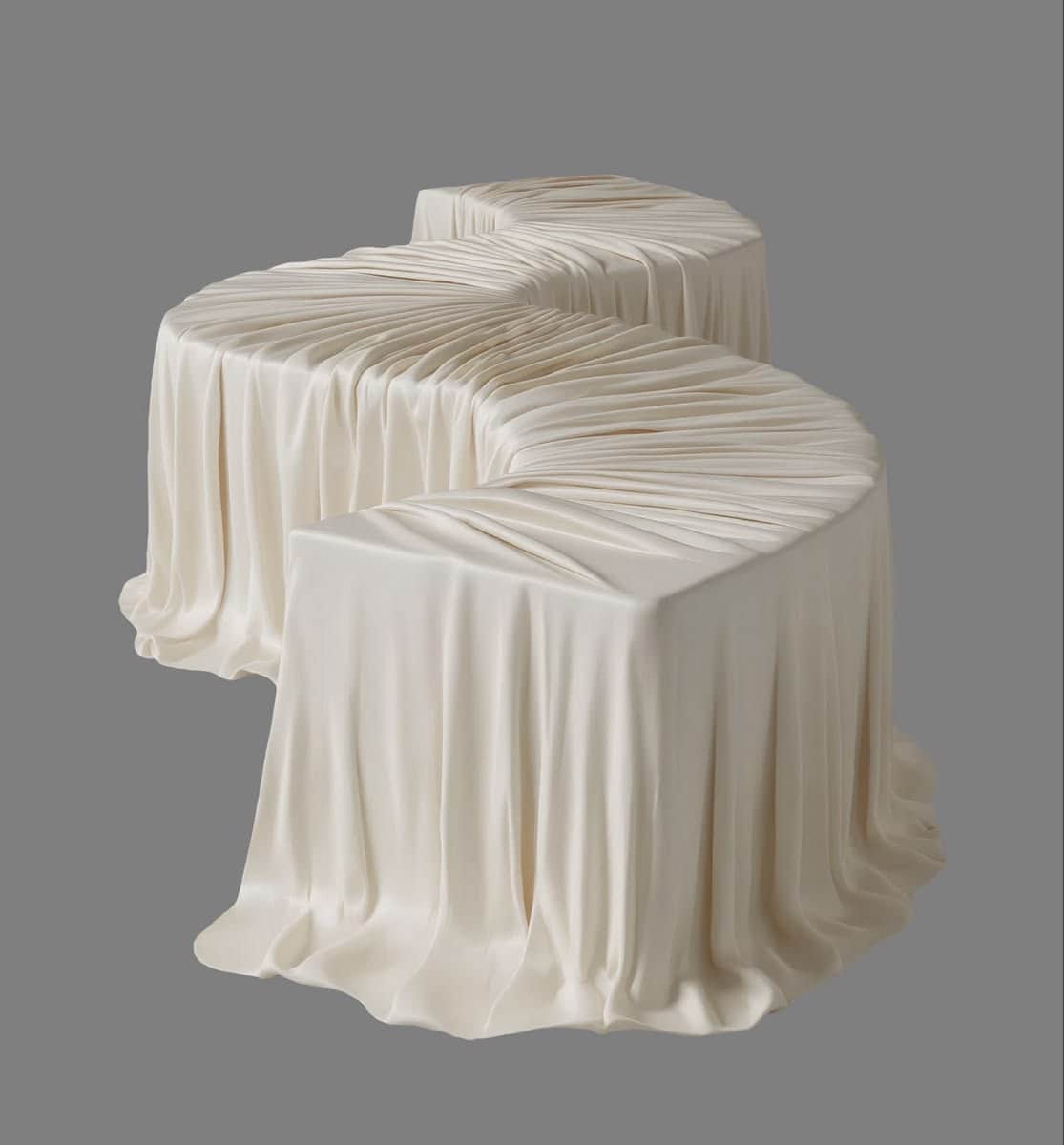 A long, serpentine-shaped bench entirely covered in a light, cream-colored fabric with an intricate… — 3D model