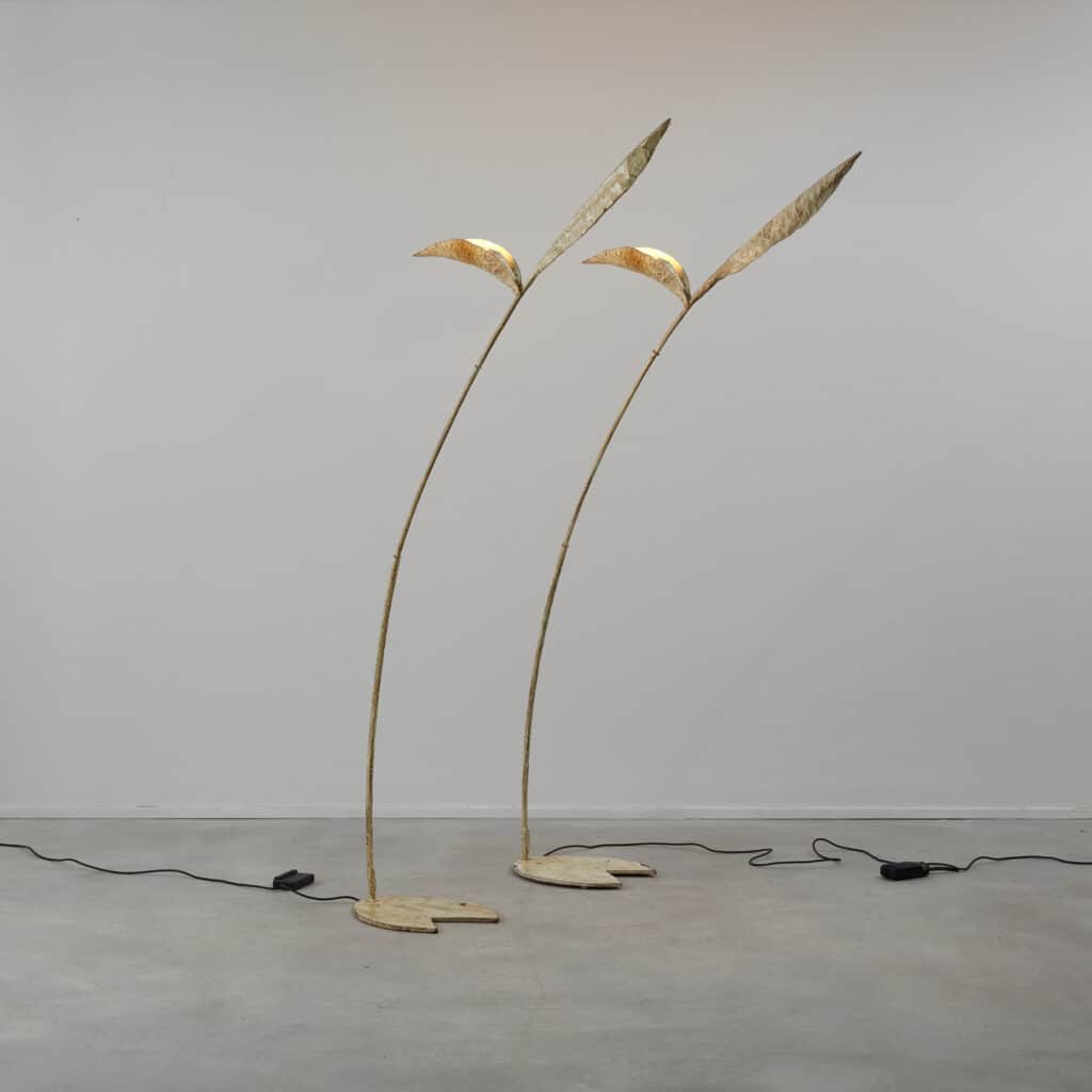 A tall, slender floor lamp with an organic, botanical design, featuring a distressed gold or bronze… — 3D model