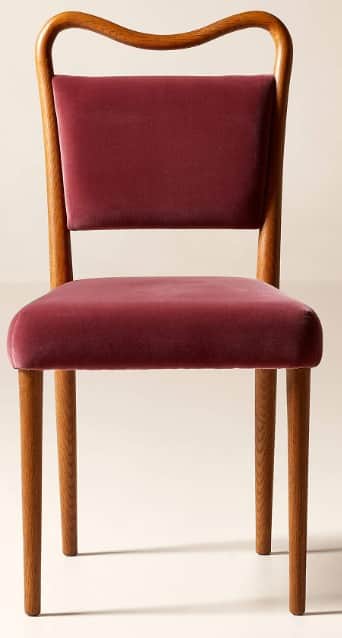 A contemporary dining chair featuring a gracefully curved wooden frame and plush velvet upholstery.… — 3D model