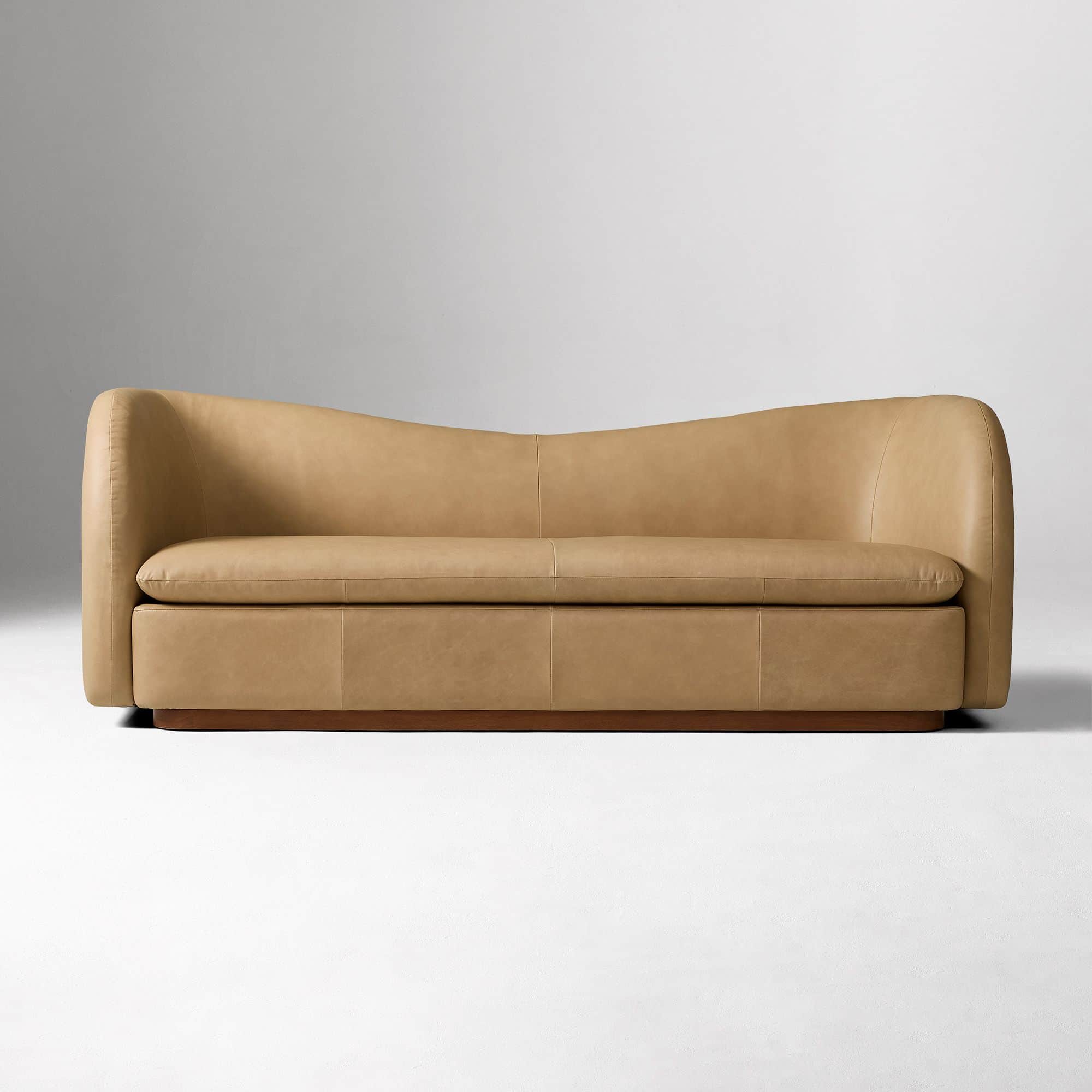 A contemporary two-seater loveseat upholstered in tan leather with a curved back and integrated armr… — 3D model
