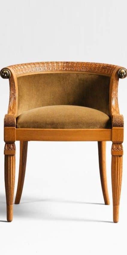 An antique armchair with a carved wooden frame and upholstered seat and back. The frame features flu… — 3D model
