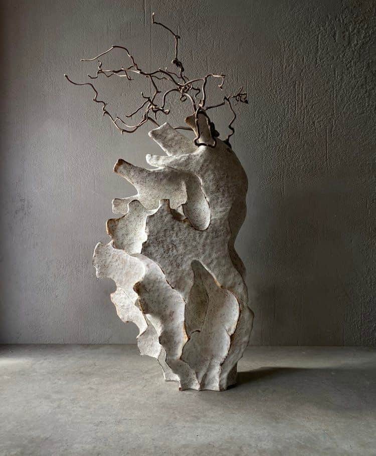 An abstract sculpture featuring a layered, biomorphic body with an organic, uneven surface texture,… — 3D model