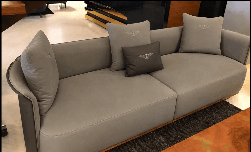 A contemporary sofa featuring a distinct curved back and armrest design with dark wood veneer paneli… — 3D model