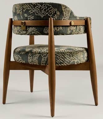A mid-century style armchair featuring a distinctive barrel back design. The chair has an exposed da… — 3D model
