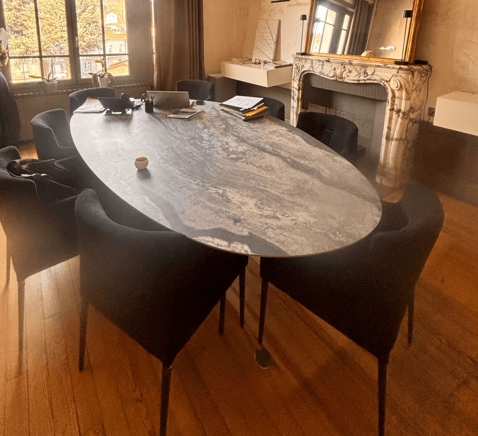 An oval-shaped coffee table featuring a grey marble-effect top with naturalistic veining, supported… — 3D model