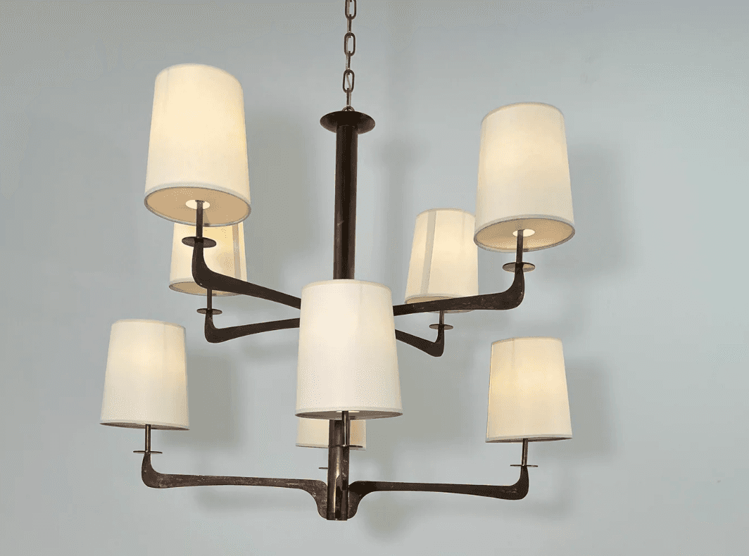 A modern multi-arm chandelier featuring a dark bronze-finished metal frame and eight tapered, drum-s… — 3D model