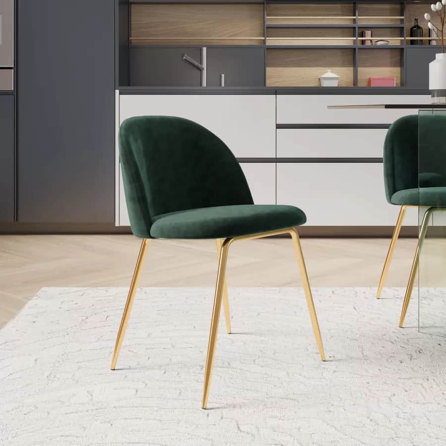 An armless dining chair featuring a curved back and seat upholstered in emerald green velvet, suppor… — 3D model