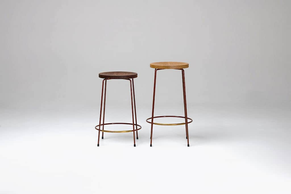 A minimalist bar stool featuring a round, natural oak wood seat and a slender four-legged metal base… — 3D model