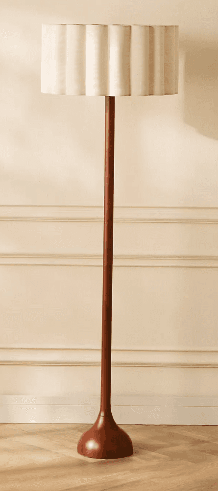 A freestanding floor lamp featuring a tall, slender wooden stem and a matching round, turned wooden… — 3D model