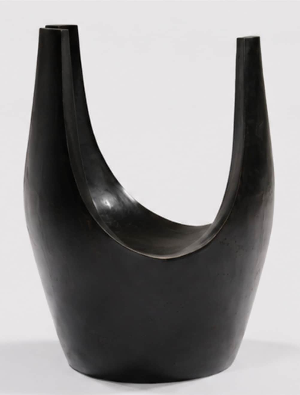 A dark, U-shaped sculptural stool, likely crafted from patinated bronze or ebonized wood. Its form i… — 3D model