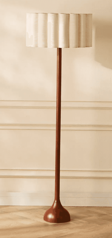 A tall, slender floor lamp featuring a dark wooden base and stem, complemented by an off-white, plea… — 3D model