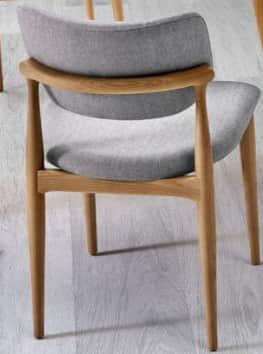 A modern Scandinavian-style dining chair featuring a light-toned wooden frame, curved back support,… — 3D model