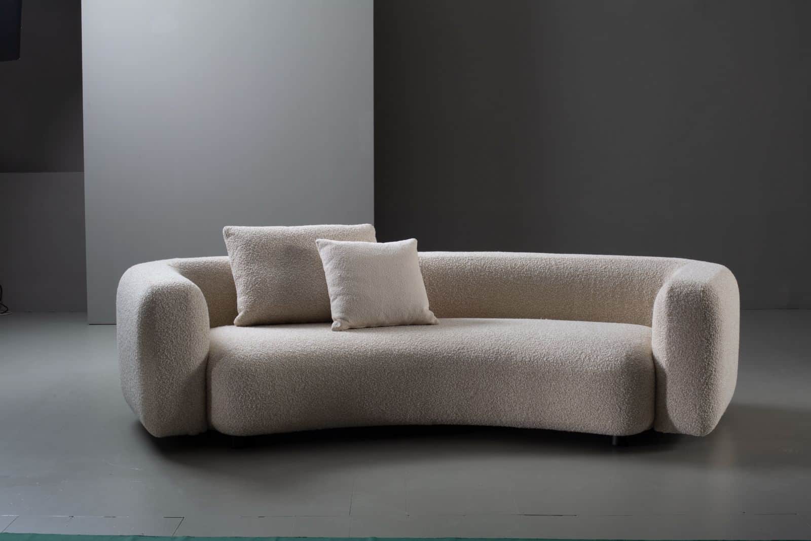A contemporary, low-profile sofa upholstered in a cream-colored boucle fabric, featuring soft, round… — 3D model