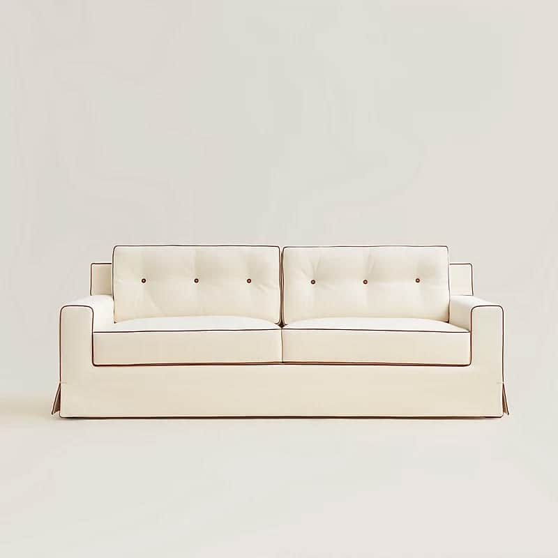 A white sofa with tufted back cushions and contrasting dark piping along the edges of the cushions a… — 3D model