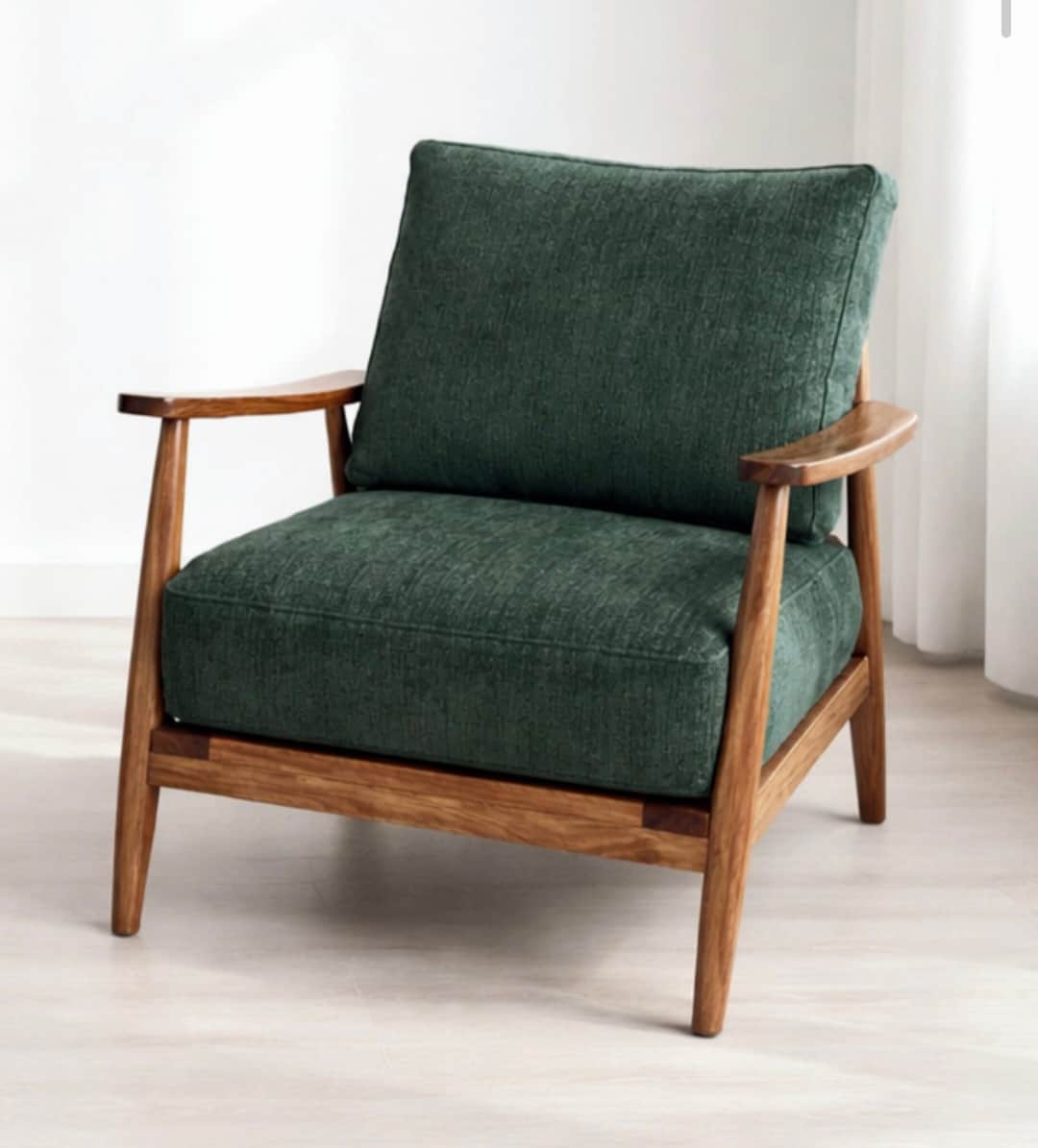 An armchair featuring an exposed wooden frame with upholstered seat and back cushions in a dark gree… — 3D model