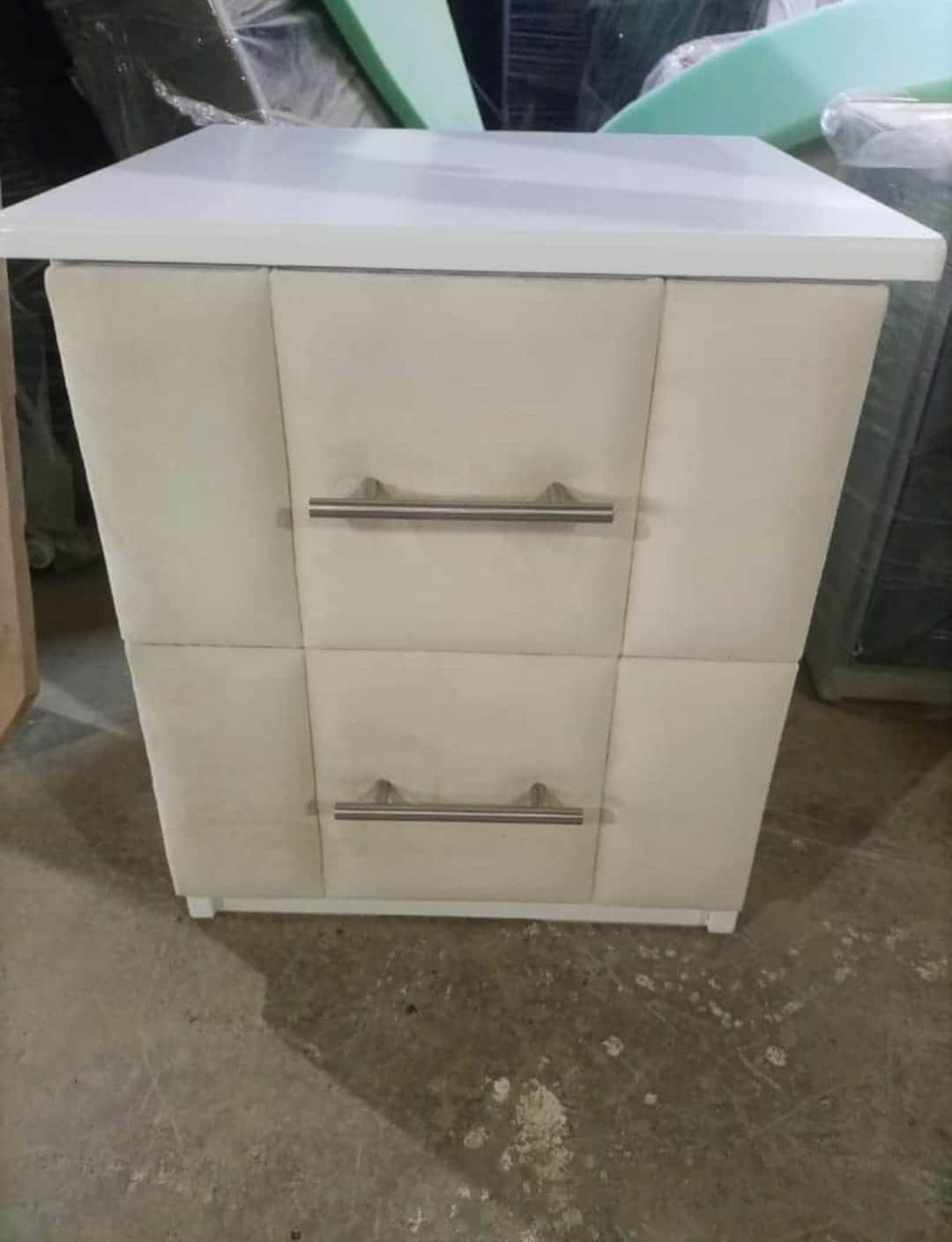 A modern two-drawer nightstand featuring upholstered cream-colored drawer fronts and a white frame w… — free FBX 3D model