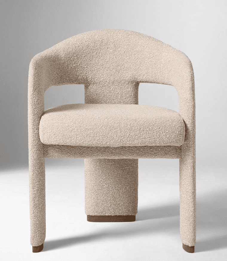 A modern armchair with a rounded backrest and armrests, upholstered in a textured boucle fabric. The… — 3D model