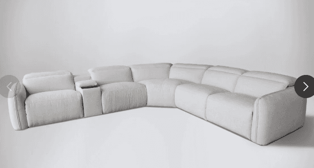 A large, L-shaped reclining sectional sofa upholstered in light beige, textured fabric. It features… — 3D model