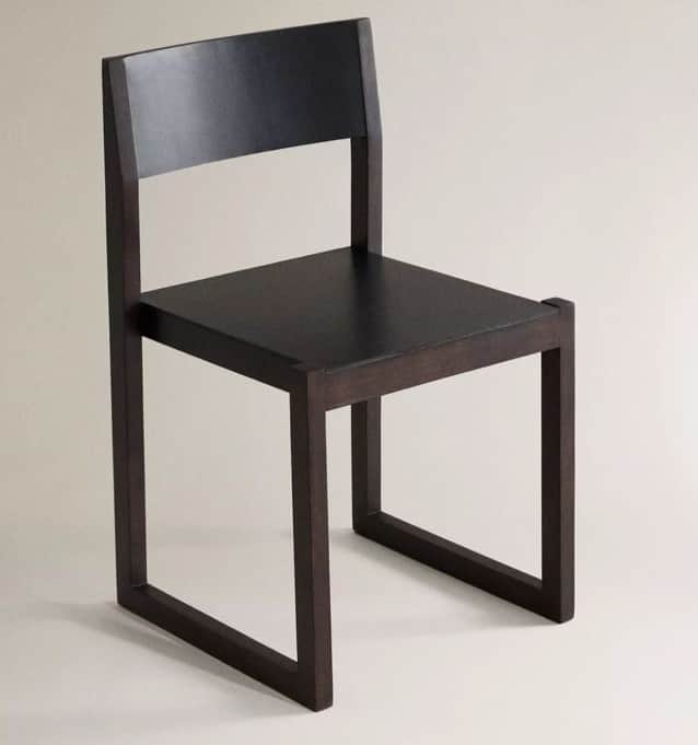 A modern chair with a minimalist design. It features a dark-colored seat and backrest, supported by… — 3D model