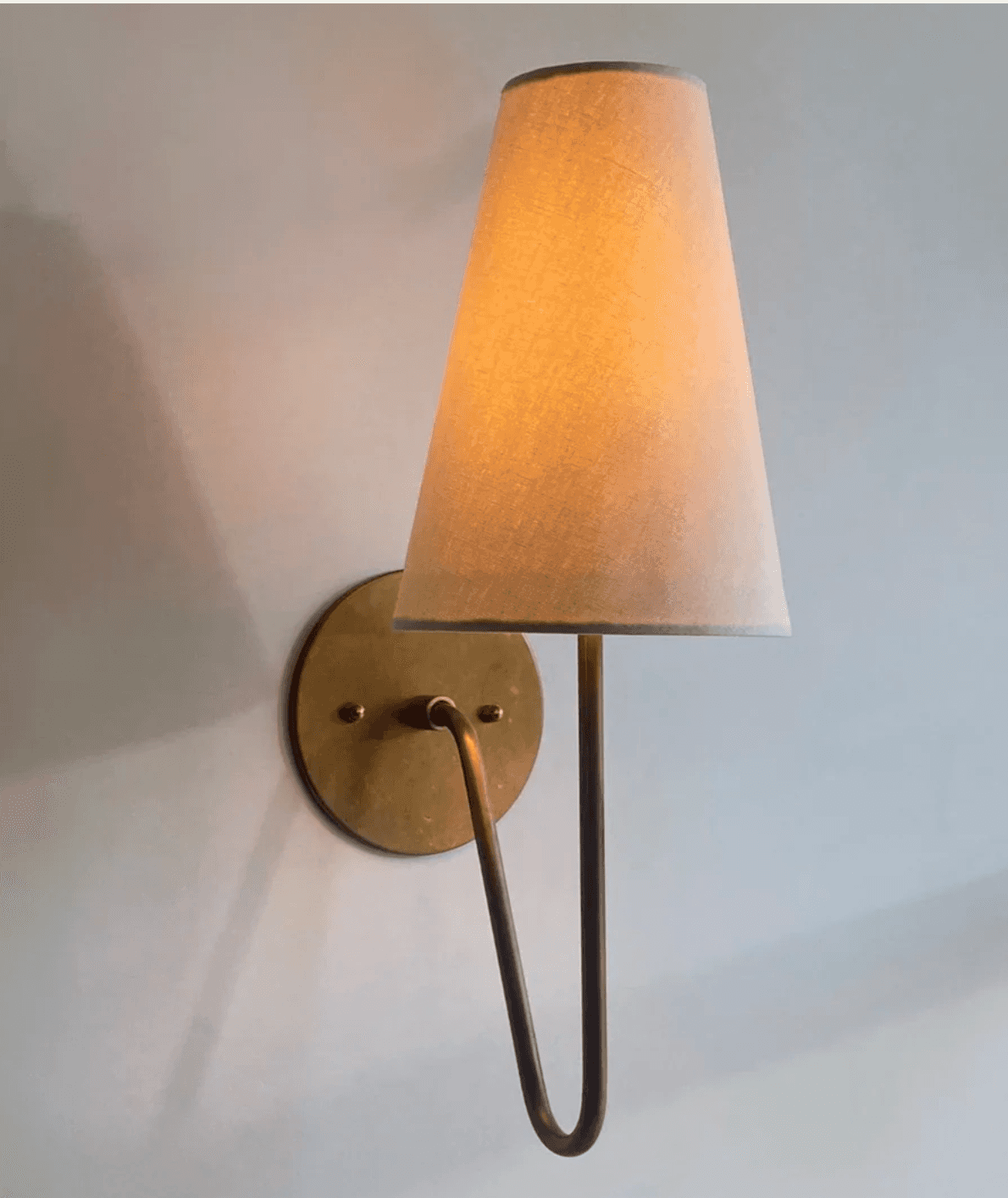 A wall lamp with a conical fabric lampshade and a brass mounting plate and arm. The lampshade is a l… — free OBJ 3D model