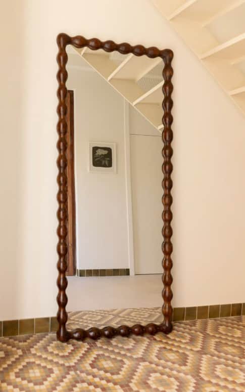 A decorative mirror with an irregularly shaped frame, featuring a repeating bobble or bead pattern a… — 3D model