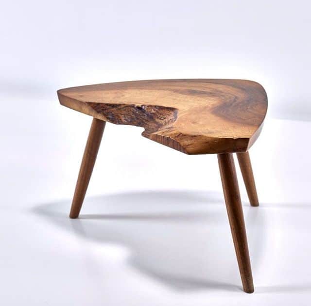 A small, irregularly shaped end table with a live-edge wooden top and three tapered wooden legs. The… — 3D model