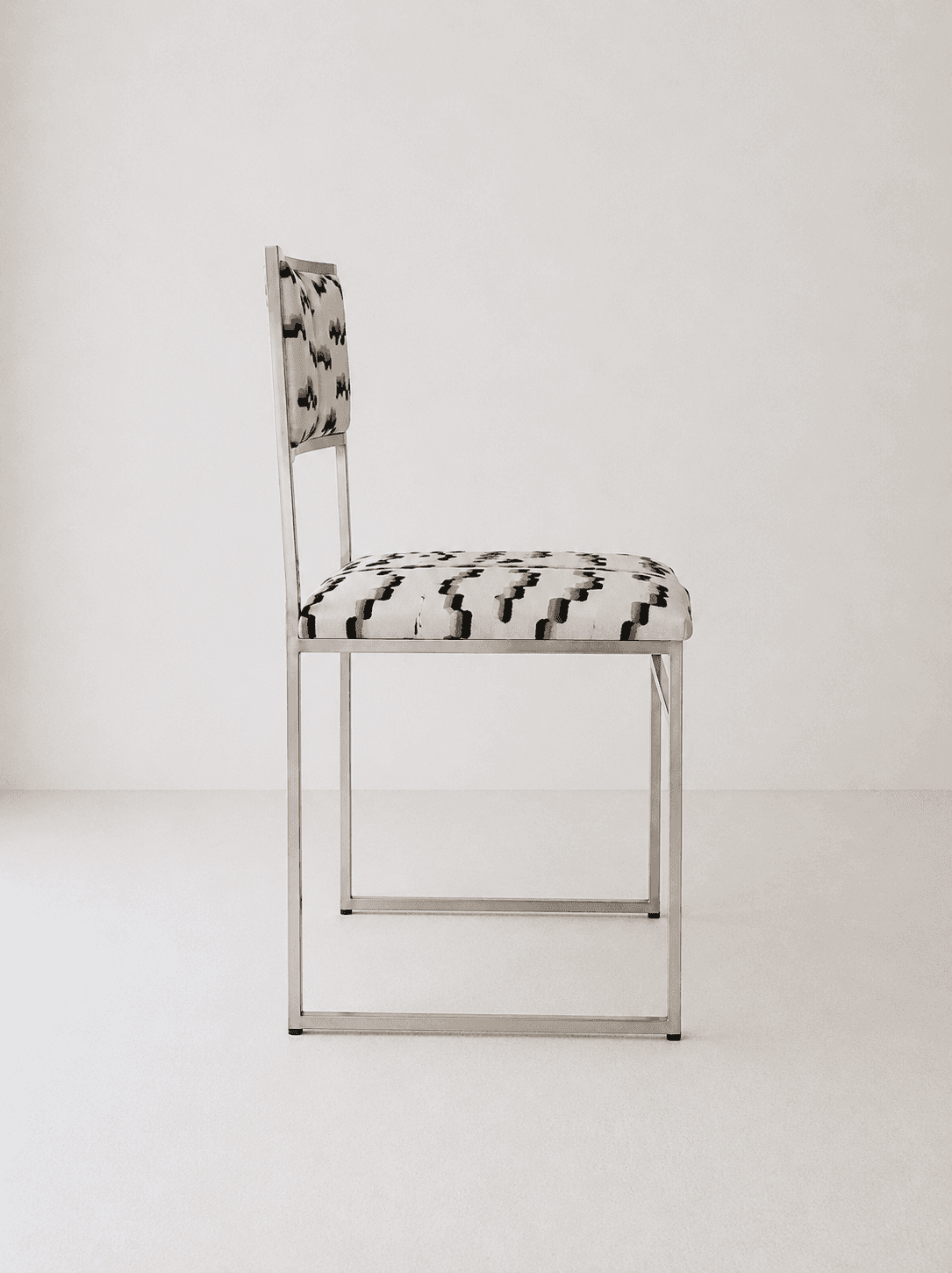 A contemporary armless chair featuring a minimalist, rectangular frame constructed from polished tub… — 3D model