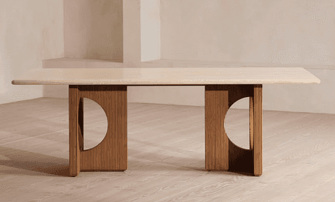 A long, rectangular dining table featuring a light-colored travertine top with rounded corners. The… — 3D model