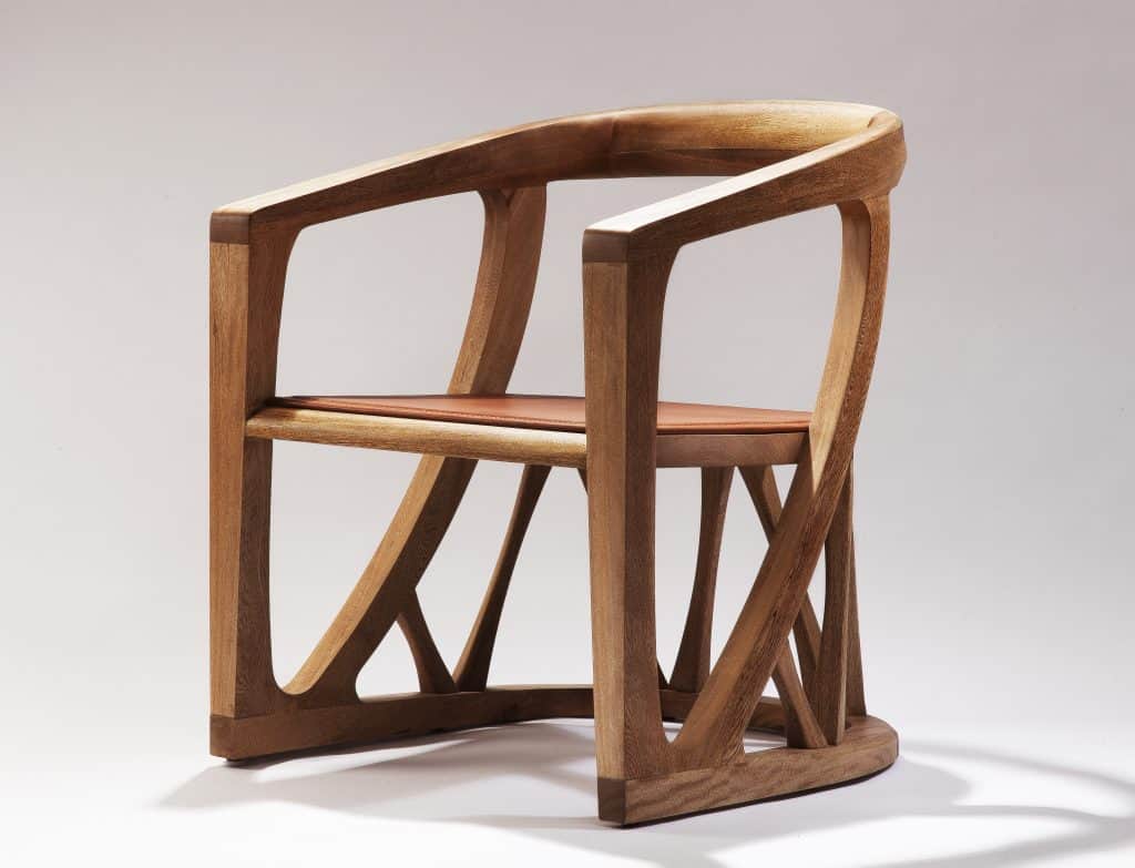 A contemporary armchair crafted from light-colored solid wood, featuring a gracefully curved backres… — 3D model
