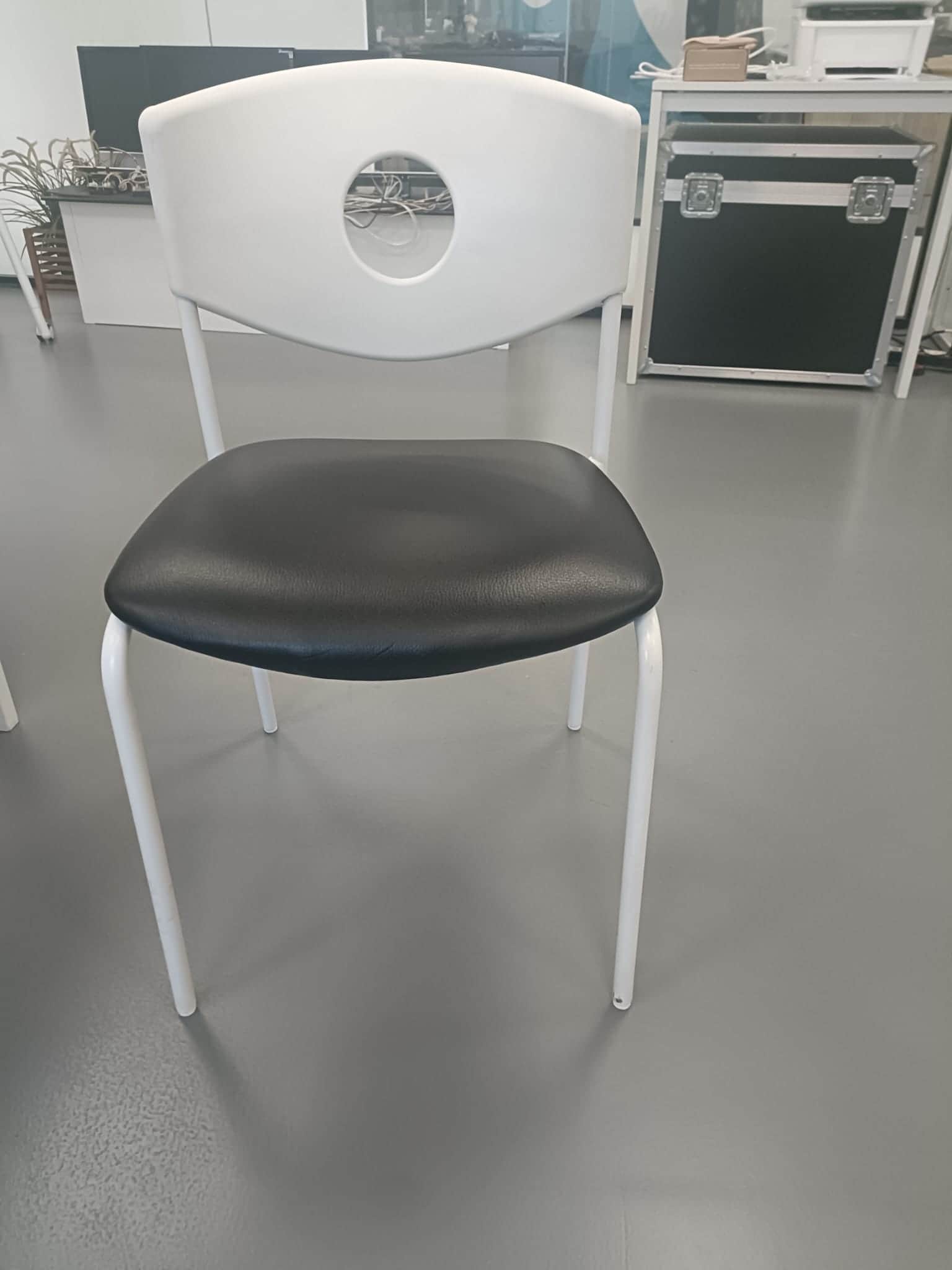 A modern chair with a white, curved backrest featuring a circular cutout. The seat is upholstered in… — free GLTF 3D model