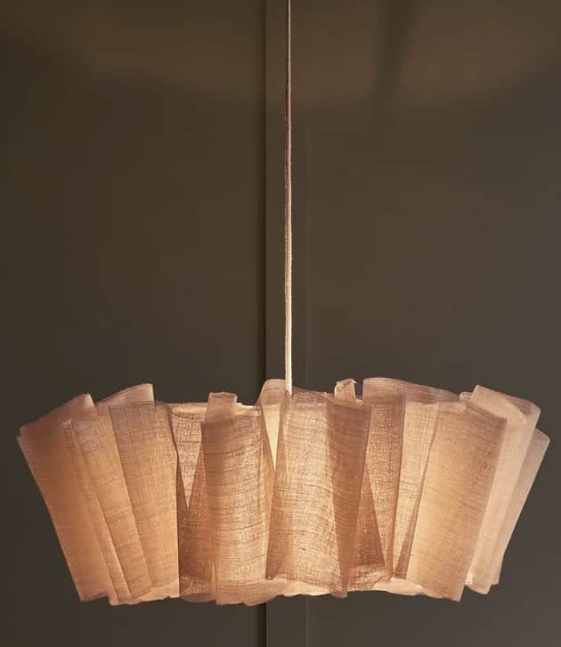 A sculptural pendant light featuring a pleated, light-colored, woven fabric shade suspended from the… — 3D model