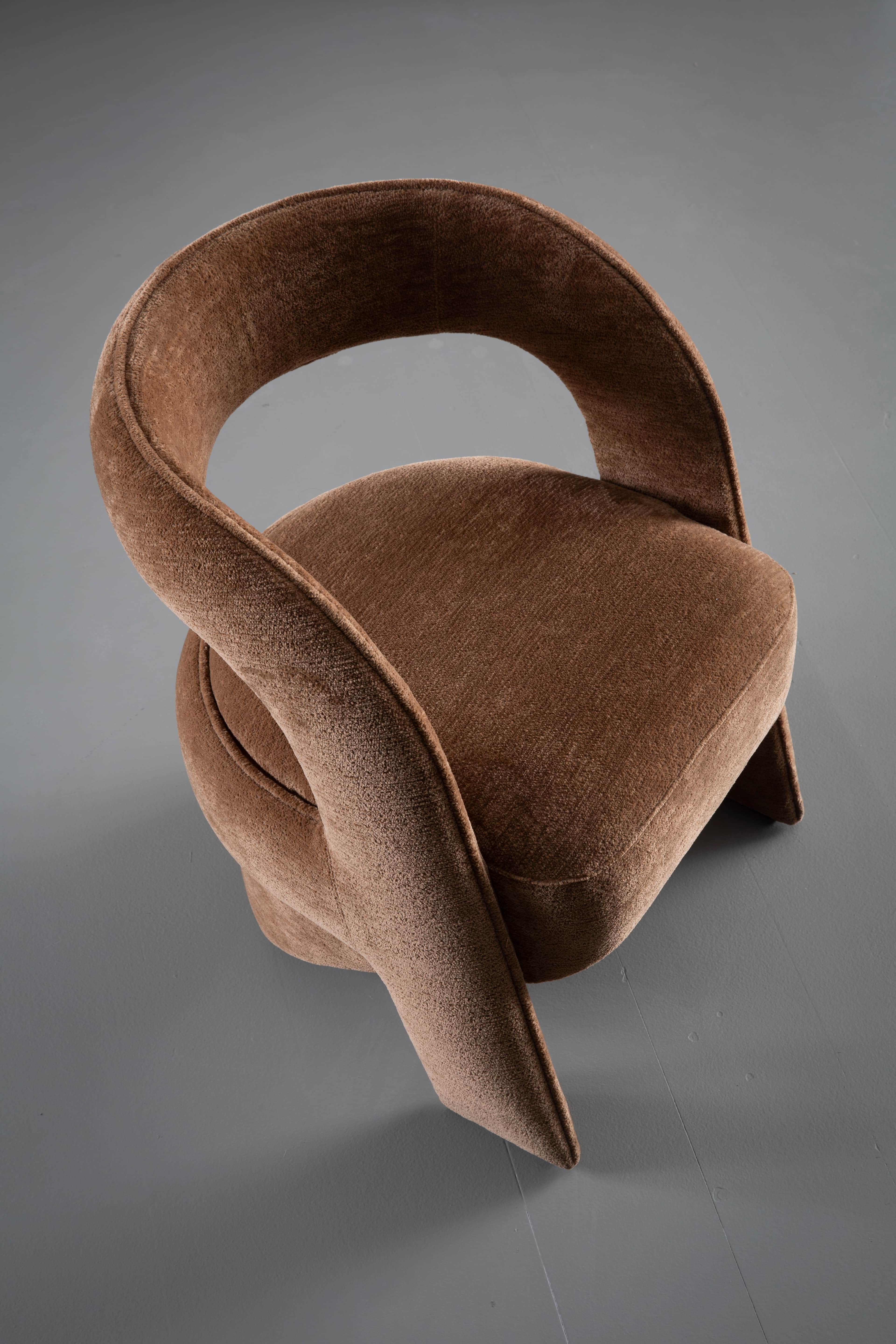 A contemporary sculptural accent chair fully upholstered in a textured medium brown fabric, featurin… — 3D model
