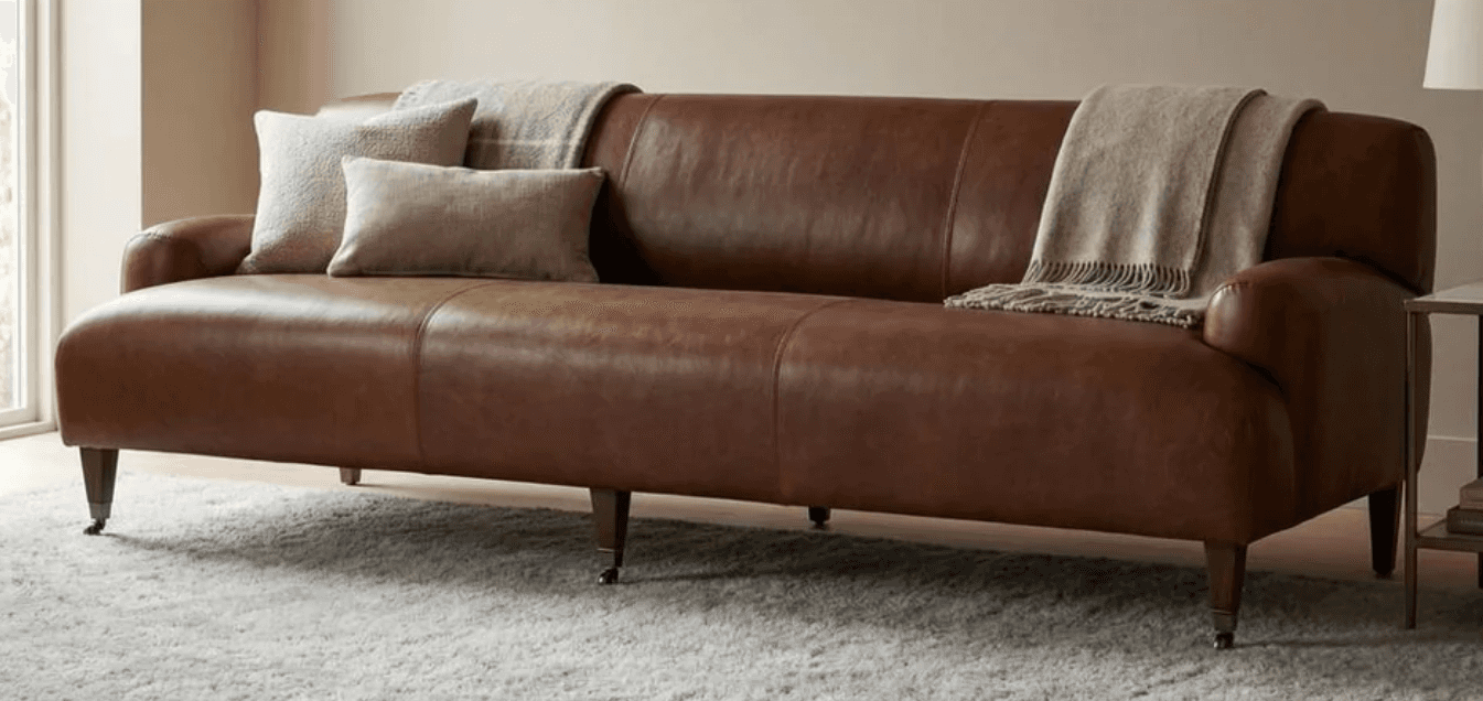 A traditional brown leather sofa featuring classic rolled arms, a single back cushion with vertical… — 3D model