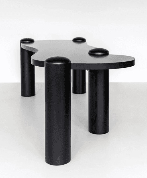 A black, abstractly shaped coffee table with a smooth, matte finish. It features a distinctively cur… — free FBX 3D model