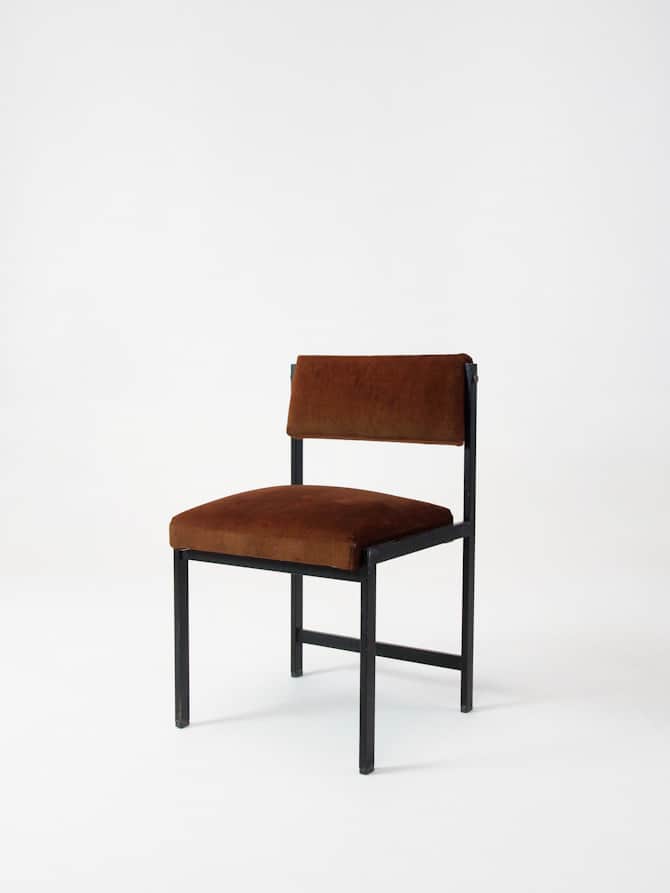 A minimalist accent chair with a dark metal frame and upholstered seat and backrest. The frame has a… — 3D model