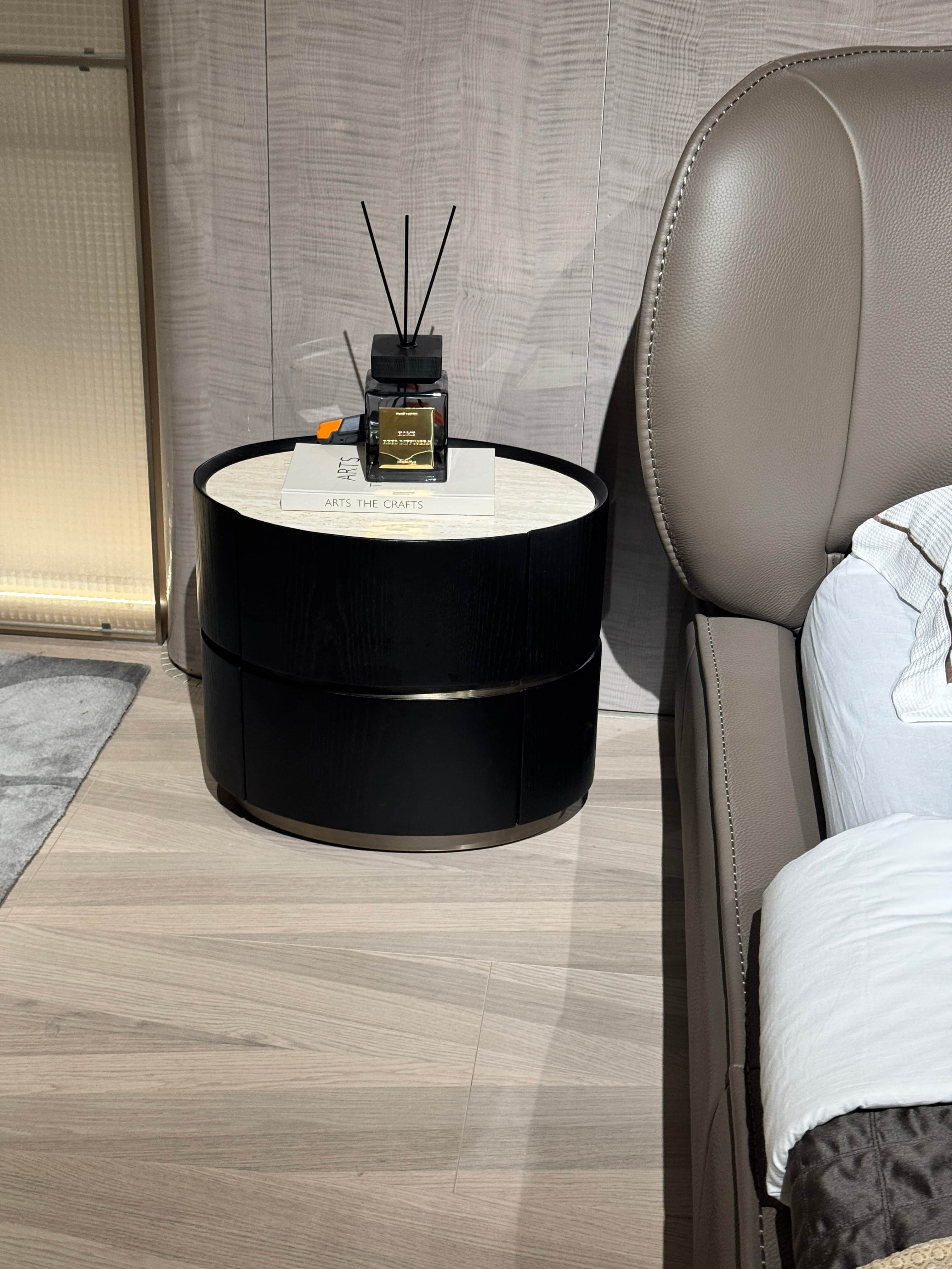 A circular end table with a dark wood finish on the exterior and a marble-patterned inlay on the top… — 3D model