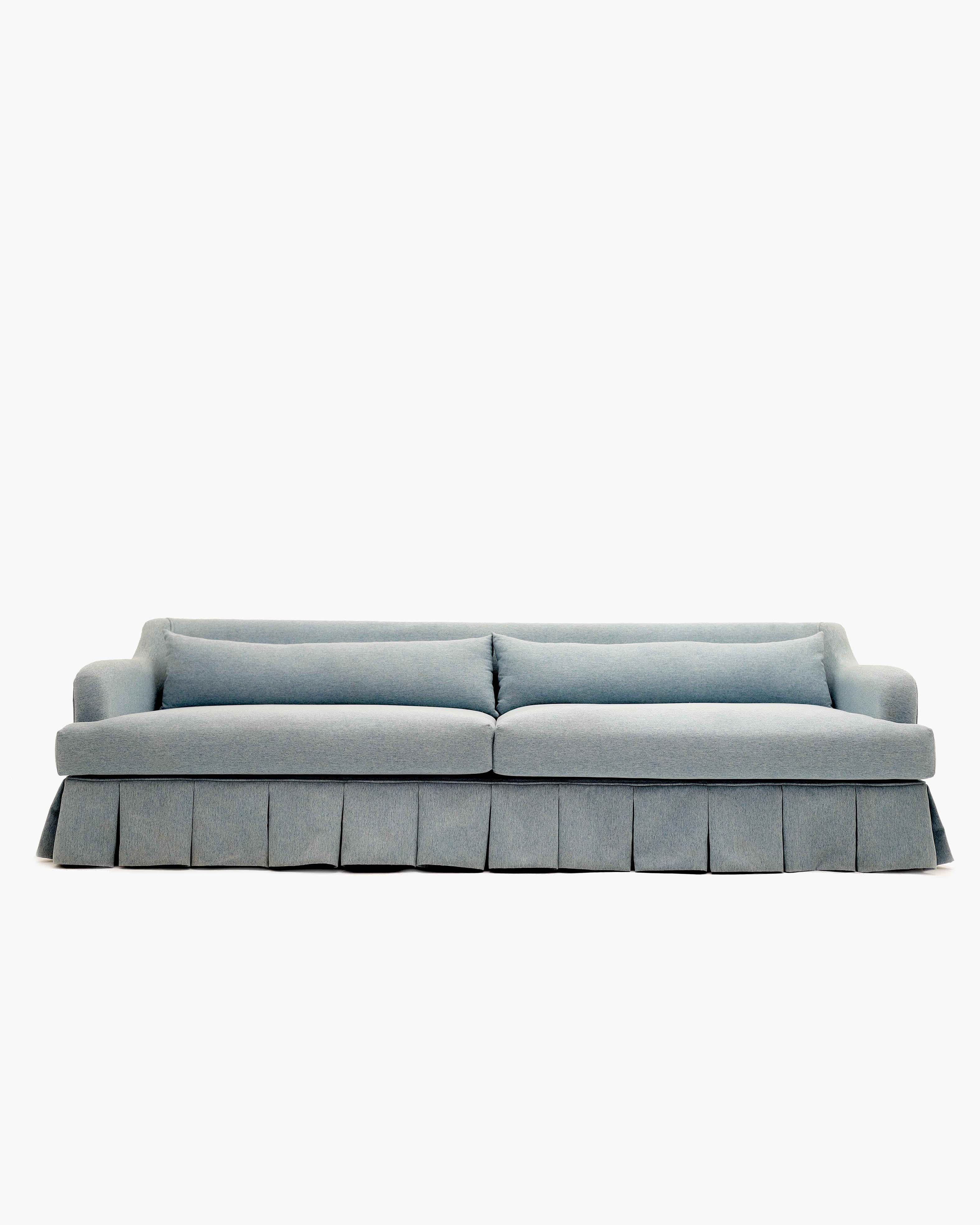 A light blue-grey two-seater sofa featuring a tailored, pleated skirted base and classic rolled arms… — 3D model