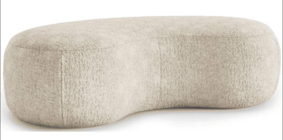 A low-profile, rounded ottoman with a unique, kidney-bean-like shape. It features a textured fabric… — 3D model