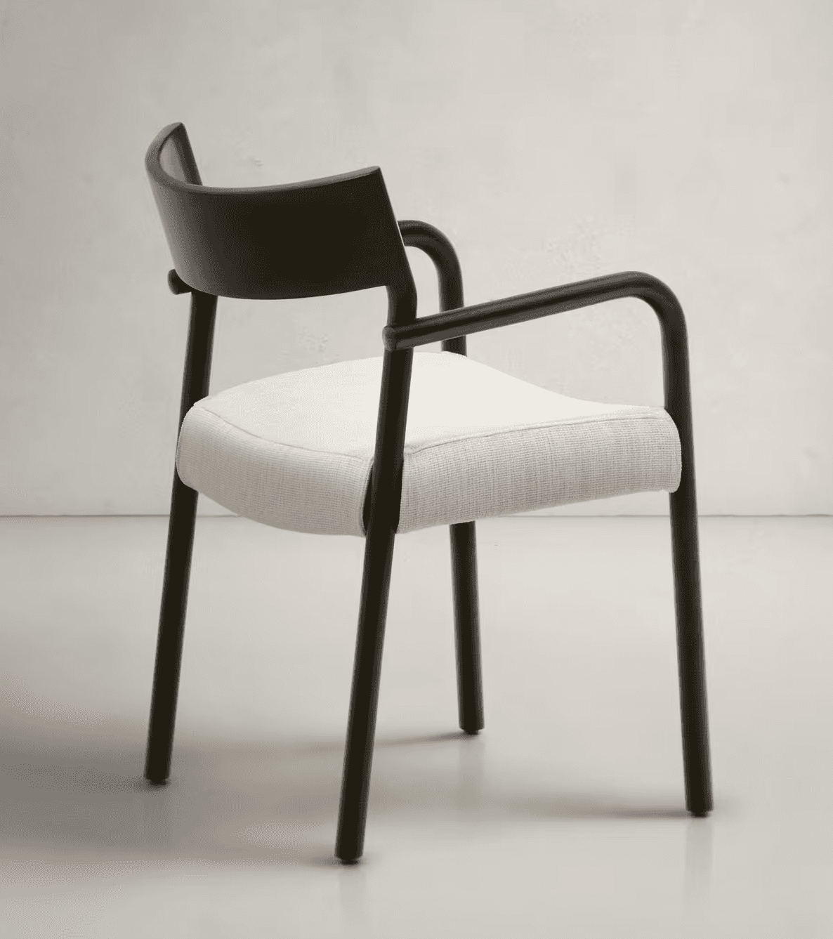 A modern armchair featuring a dark, matte-finished frame with a curved backrest and arms. The seat i… — 3D model