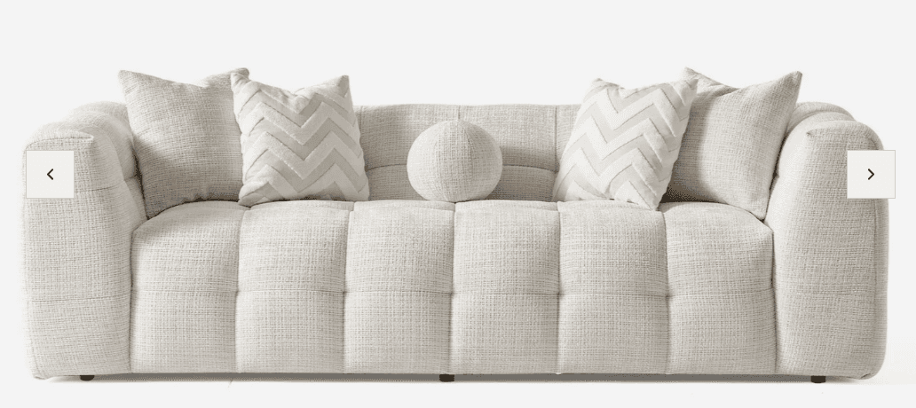 A long, low-profile contemporary sofa upholstered in a light beige, textured fabric. It features dee… — 3D model